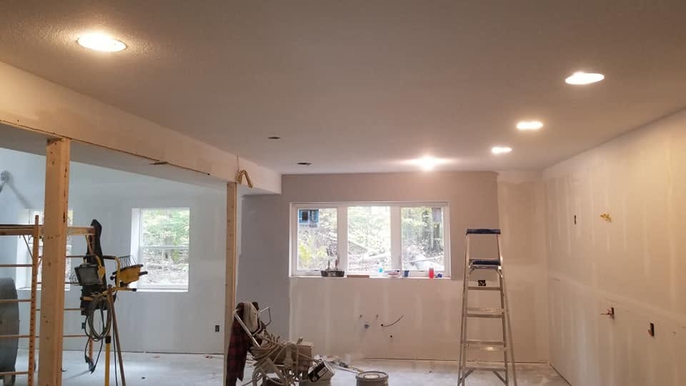 Drywall in progress — ladder and windows