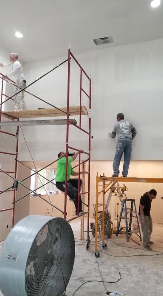 Drywall crew on scaffolding