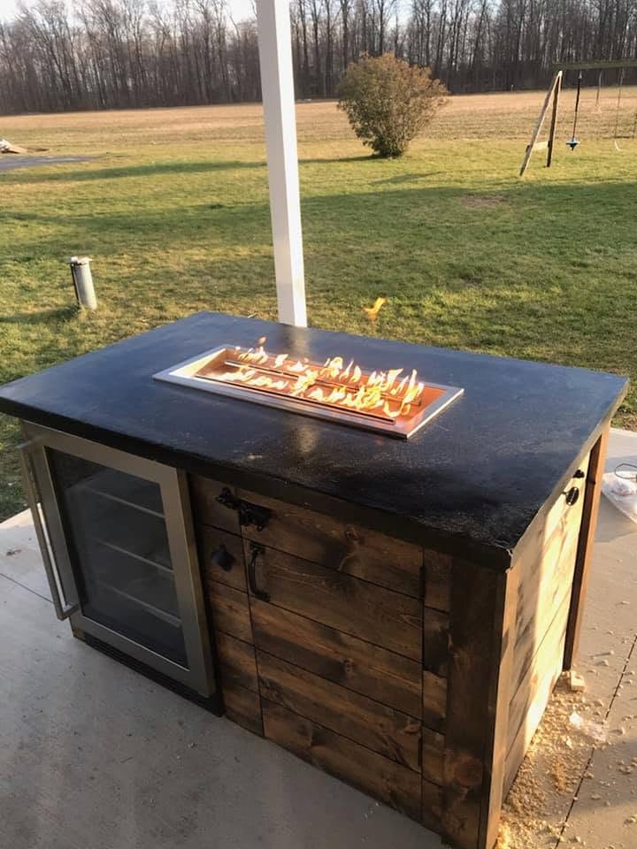 Custom fire table with a concrete top, lit at dusk